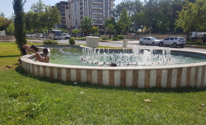 Sıcakta bunalan çocuklar süs havuzunda serinliyor