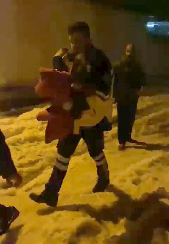 Sağlık personeli karlı yolda hastayı kucağında taşıdı